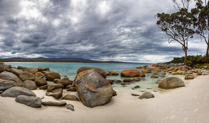 Panorama of stormy skies at Binalong Bay, Bay of Fires area of Tasmania. The rocks and boulders...