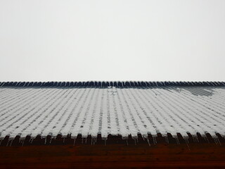 Obraz premium Frosted country house roof with icicles abstract