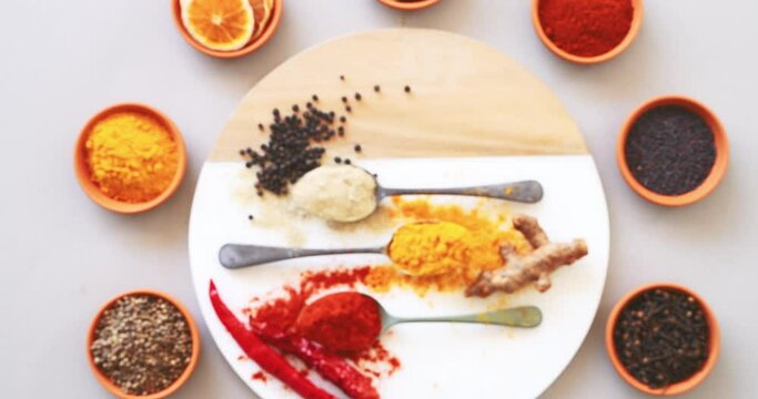 Top view, spices and herbs or powder on table in kitchen for cooking, food or seasoning collection with color. Curry, oranges and tumeric or salt with seeds, cumin and masala on arrangement board