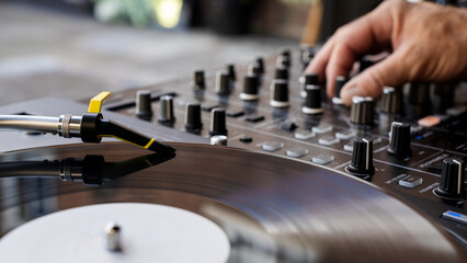 A DJ moving a fader on a mixing console	
