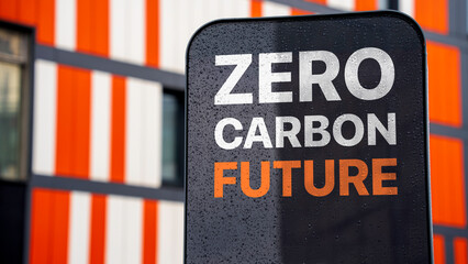 Zero carbon future on a sign in a city business district - obrazy, fototapety, plakaty