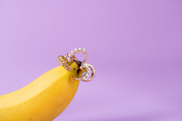 Intimate piercing. Minimal piercing concept. Banana with inserted iron decoration, piercing