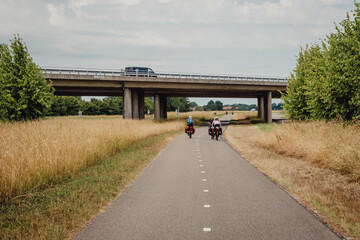 Familie auf einer Radreise durch Holland unterquert eine Autobahnbrücke