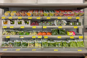 clean bagged vegetables and salads and soups of various types in packages displayed in display case refrigerated counter shelf for sale in Italian supermarket
