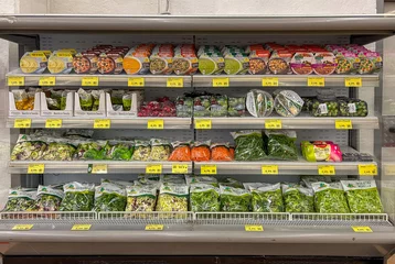 Poster clean bagged vegetables and salads and soups of various types in packages displayed in display case refrigerated counter shelf for sale in Italian supermarket © framarzo