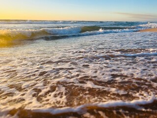 warm light of the sunset sun at the ocean shore, sandy beach