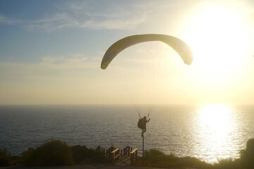 paraglider standing on a stake at the Atlantic Ocean during the sunset, Costa de la Luz, Andalusia,...