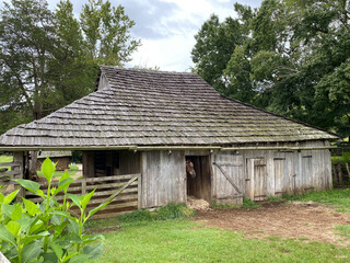 Fototapeta na wymiar Horse barn at Booker T. Washington National Monument in rural Virginia. Tobacco farm where educator and leader Booker T. Washington was born into slavery and later freed by Emancipation Proclamation.
