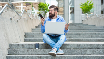 Upset man lost bet. Nervous guy checking up betting results in mobile phone