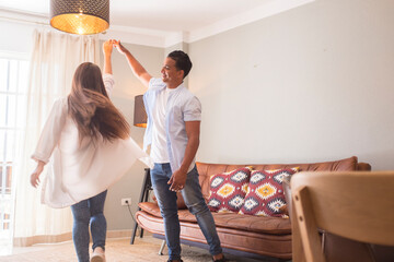 Happy loving couple having fun in the hall, dancing together, celebrating a move or anniversary,...