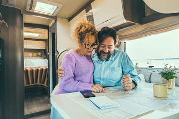 couple sitting in camper planning trips, smiling. Adventurous life concept