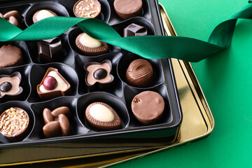Box with delicious chocolate candies on colorful background