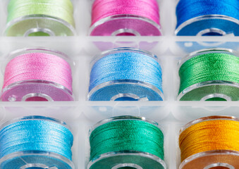 Plastic bobbins for a sewing machine with multi-colored threads.
