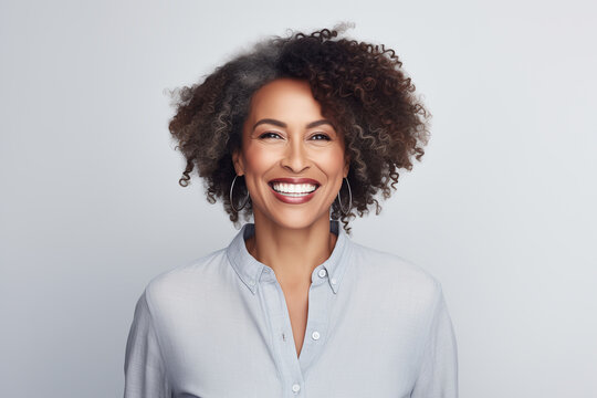 A photo portrait of a beautiful afro-american woman over 40 years old, smiling with clean teeth, perfect teeth. To advertise dentistry. Highlighted on a white background