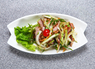 Grilled pork neck salad in thai style with tomato, cucumber and lettuce leaf served in dish isolated on grey background top view of hong kong food
