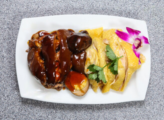 Braised Pork Trotter with hai nam chicken in thai style with sauce served in dish isolated on grey background top view of hong kong food