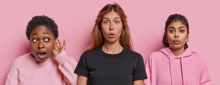 Collage image of stunned diverse young women stare with omg expressions at camera keep hand near ear and try to overhear information dressed casually isolated over pink background. Omg concept