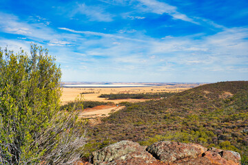 View over forested hills, wheat fields and the salt lake Lake Hinds from the Mt. Matilda Trail in Wongan Hills Nature Reserve, in the Wheatbelt of Western Australia
