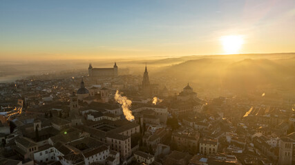 Naklejka premium Aerial views of the Alcázar of Toledo during sunrise with sun rays, on a winter day with haze, drone, uas