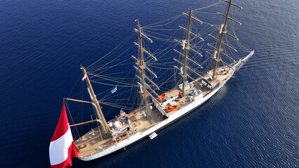 Aerial drone photo of beautiful 3 mast barque or barc type classic sailing wooden boat anchored in...