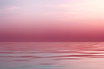 Ocean in a tranquil scene, under a gradient pink sky at dusk.