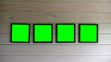Photo frames with a green background on the wall