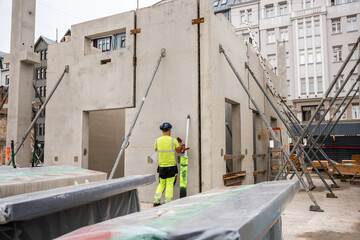 construction in urban core with worker, scaffolding, and concrete structures