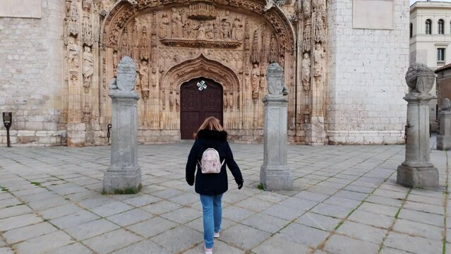 Tourist woman in front of the impressive facade of the church of San Pablo in Valladolid.