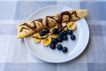 Traditional Ukrainian pancakes with bananas, chocolate and blueberry