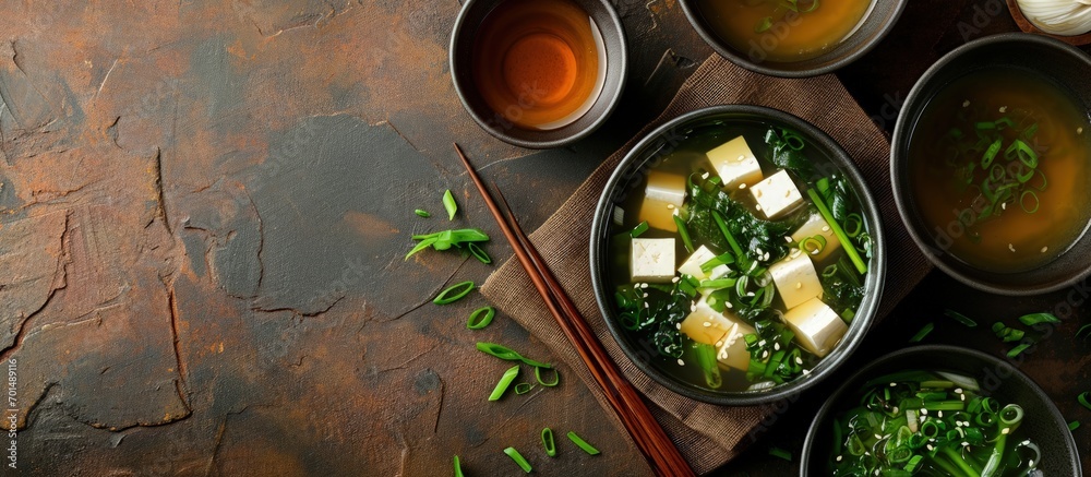 Aufkleber miso traditional japanese soup with tofu and spring onion with green tea in pot and bowls top view. 