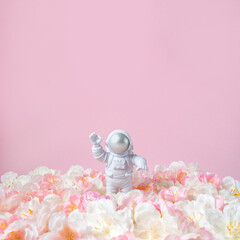 Astronaut and flower meadow. Square banner congratulations. Selective focus, copy space