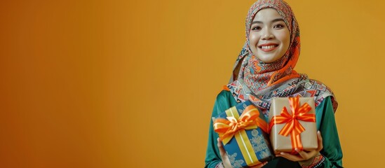 Young Asian Muslim prepares a special gift for the end of fasting Ramadan for her family and loved ones Happy young muslim woman with surprise gift boxes. Creative Banner. Copyspace image