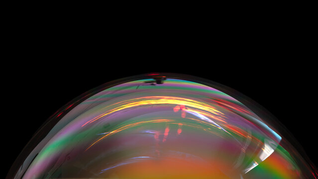 Iridescent soap bubble on black background.