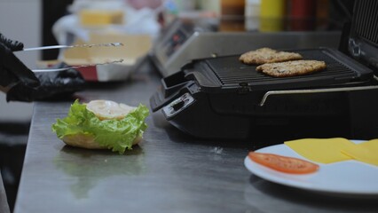 Cook the hamburgers on a hot grill pan. Cooking, fast food concept. Vegetarian delicious burger, meat substitute patty. Sesame hamburger bun.