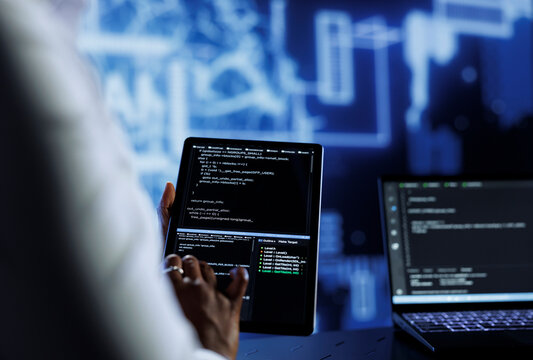 Admin updates neural networks made up of interconnected nodes, writing intricate binary code scripts on tablet and laptop, close up. Data center expert uses programming to upgrade AI simulation model - Powered by Adobe