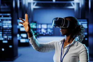 Computer scientist in data center uses virtual reality to prevent system overload. African american...