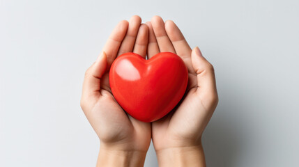 Palms cradle a smooth red heart, a universal sign of love and health on World Health Day.