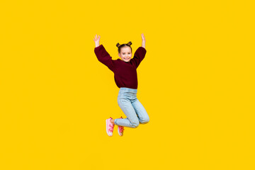 Fototapeta na wymiar Full size portrait of cheerful carefree girl jumping flying raise hands isolated on yellow color background