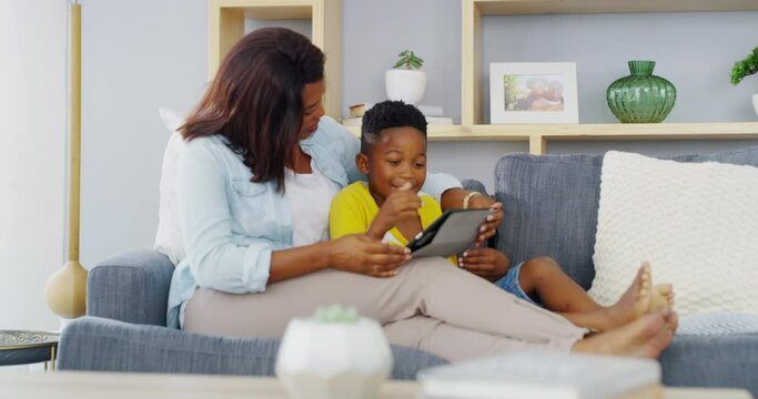 Kid, mother and happy with tablet on sofa to play video games, watch movies and elearning app at home. Mom, boy child and black family streaming cartoon, digital ebook story or educational multimedia