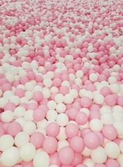 Many plaster balls pink and white dry pool kids activity in kindergarten background 