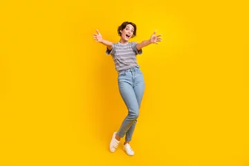 Foto op Canvas Full size portrait of astonished cheerful girl raise opened hands welcome you isolated on yellow color background © deagreez