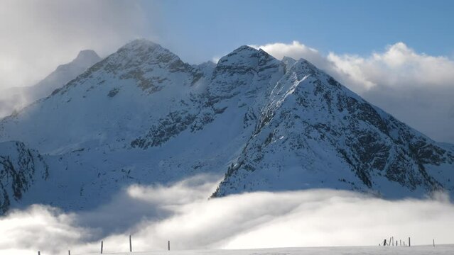 mountain peaks rising from cloud in ski resort