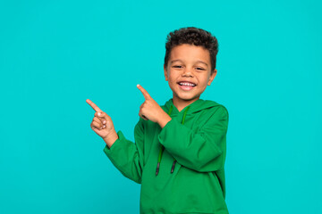 Photo of satisfied cheerful boy dressed trendy green clothes offer proposition empty space isolated...