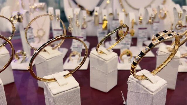 Women's gold bracelets in a jewelry store window. Close-up