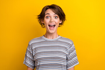 Portrait of impressed overjoyed girl with short hairstyle wear grey t-shirt astonihsed staring...