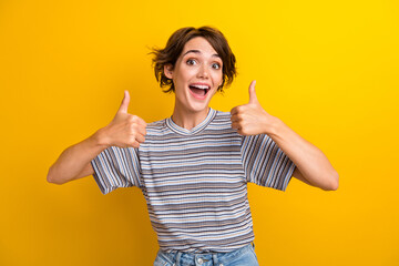 Portrait of impressed ecstatic girl with short hairstyle wear grey t-shirt showing thumbs up...
