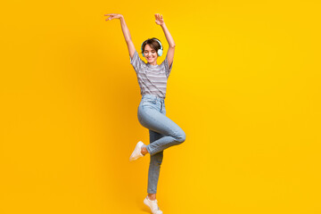 Full size photo of overjoyed pretty girl raise arms have good mood dancing empty space isolated on...