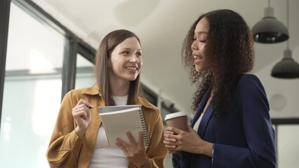 Caucasian and an African American university woman engaged in a conversation, meeting together.
