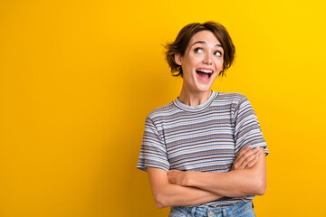 Photo of impressed woman with bob hairdo dressed t-shirt look at discount empty space arms crossed isolated on yellow color background - obrazy, fototapety, plakaty