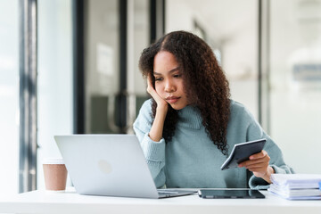 African American university student looking worried or stressed while working on her MBA project on...
